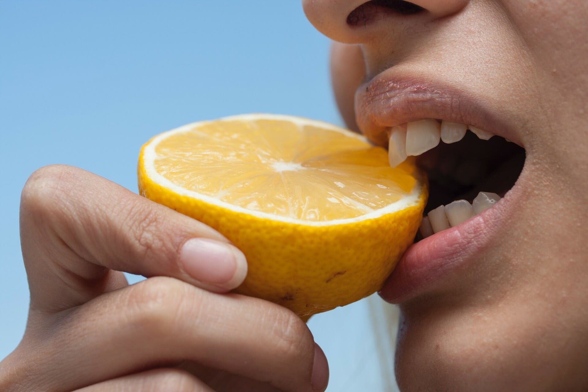 vrouw bijt in sinaasappel