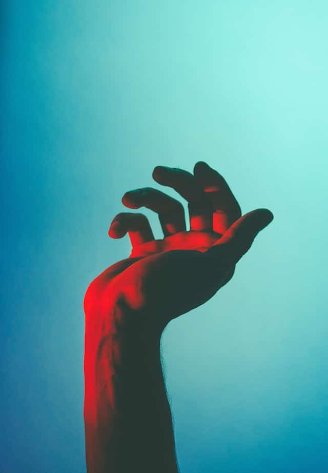 een hand in gekleurd licht